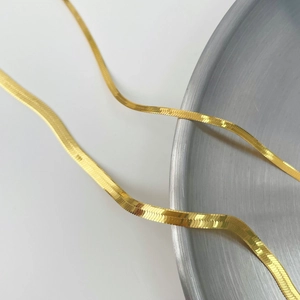 Close-up of flexible gold herringbone snake chain with high-polished mirror finish