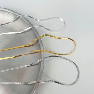 Detailed close-up of flat snake bone necklaces in polished gold and silver finishes