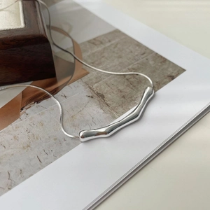 Macro detail of S925 sterling silver snake chain with irregular liquid metal pendant
