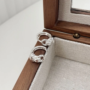 Detailed macro view of S925 sterling silver knotted double-layer twist hoop earrings