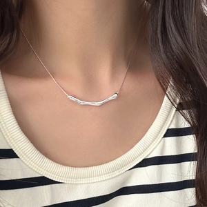 Close-up of minimalist S925 silver snake chain with organic curved bar pendant on model