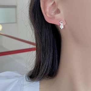 Close-up of S925 sterling silver double-layered knotted hoop earrings on model