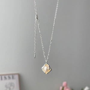 Macro shot of 925 sterling silver chain with irregular metal frame and white pearl pendant