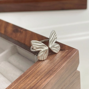 Detail of S925 sterling silver butterfly ring with matte brushed finish on wooden box