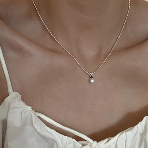 Detail of S925 silver necklace featuring a fresh white pearl and black cubic zirconia