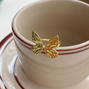 Elegant S925 sterling silver butterfly ring with textured wings on ceramic cup