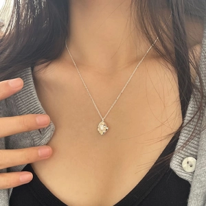 Close-up of minimalist 925 silver necklace with irregular organic pearl pendant on model