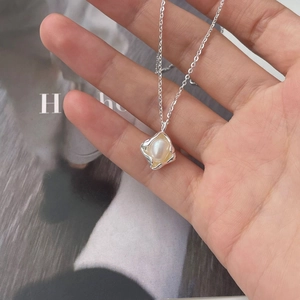 Detailed close-up of a 925 sterling silver irregular pearl pendant held in hand