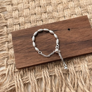 Detailed close-up of S925 sterling silver beaded chain jewelry on rustic wood background