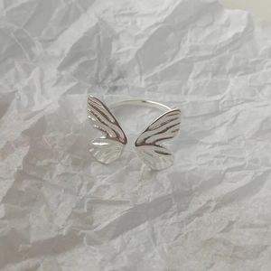 Macro detail of S925 sterling silver butterfly ring with wings on white paper