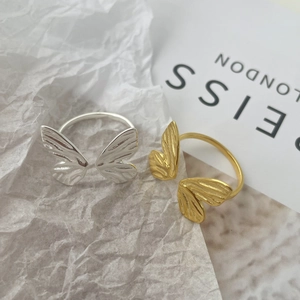 Macro detail of the butterfly wings texture on silver and gold minimalist open rings
