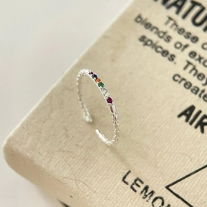 Macro shot of S925 silver ring with colorful rainbow cubic zirconia and textured band