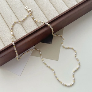 Collier minimaliste en perles or et argent avec perles olive sur boîte en bois