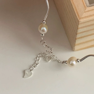 Detail of 925 sterling silver lobster clasp and heart tag with fresh water pearls