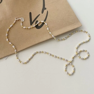 Gros plan du collier bicolore en argent S925 avec perles olives et perles rondes dorées