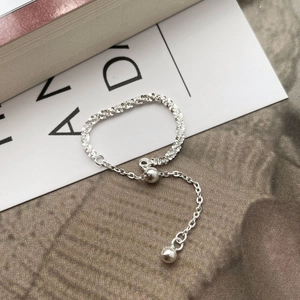 Detail of adjustable S925 sterling silver double chain ring with textured bead charms
