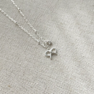 Macro detail of S925 silver bow pendant necklace with a sparkling round zircon stone