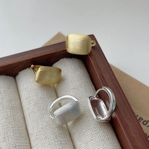 Gros plan de boucles d'oreilles S925 en argent sterling avec texture brossée et mate