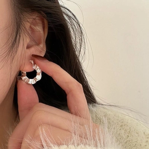Close-up of S925 sterling silver hoop earring with unique wrinkled texture on model