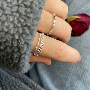 Detail of S925 sterling silver double-layer chain and beaded rings worn on finger