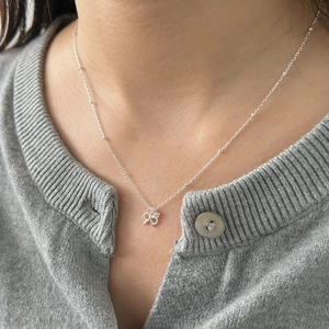 Elegant S925 sterling silver bow pendant necklace worn on a woman's neck