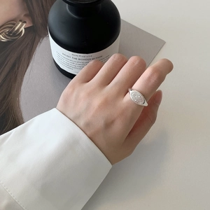 Gros plan d'une bague vintage en argent 925 avec relief solaire portée à la main