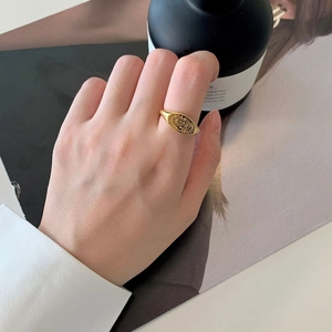 Détail d'une bague chevalière dorée vintage avec gravure solaire et fini métal brossé