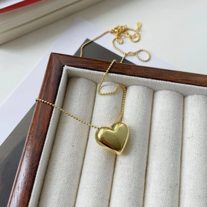 Vue macro d'un collier pendentif cœur en argent sterling S925 poli dans un coffret en bois