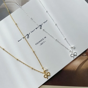 Close-up of S925 sterling silver bow pendant necklaces with zircon in gold and silver