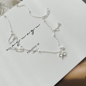 Close-up of S925 sterling silver necklace featuring a bow and sparkling star pendant