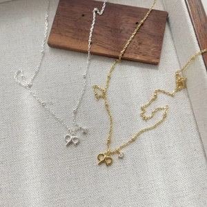 Detailed view of gold and silver S925 sterling silver bow necklaces with zircon stones