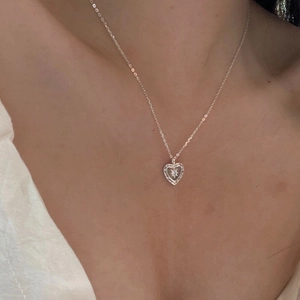 Close-up of S925 silver heart necklace with star-shaped zirconia pendant on a model