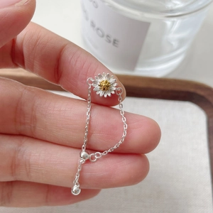 Detail of adjustable S925 sterling silver daisy chain ring with yellow center