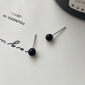 Macro shot of S925 sterling silver stamp on minimalist black onyx round stud earrings