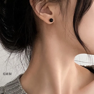 Detailed macro view of a 6MM black onyx stud earring worn on a female earlobe