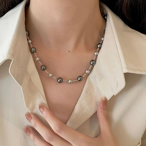 Close-up of grey gradient pearl necklace with silver accents on a female model