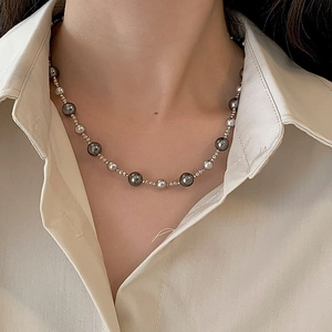 Macro detail of gradient Tahitian grey pearl necklace with metallic spacers on model