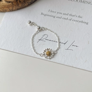 Detail showing the adjustable S925 silver daisy chain ring with golden floral accents