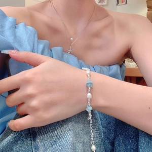 Dettaglio del bracciale con perle barocche e acquamarina con collana pendente stella marina