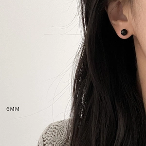 Close-up of 6mm black agate stud earring on ear showing minimalist round bead style