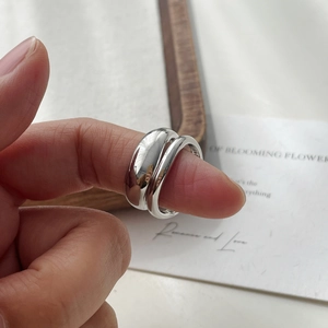 Detailed view of irregular 925 silver wave ring with S925 hallmark on female hand