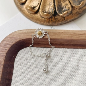 Detail of adjustable S925 sterling silver daisy ring with chain and sliding gold ball