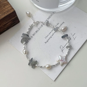 Dettaglio del bracciale in argento S925 con perle, pietre grigie e conchiglia a forma di stella