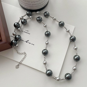 Detailed view of the S925 silver heart pendant and gradient grey pearl necklace