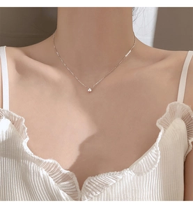 Nahaufnahme einer filigranen S925 Silberkette mit Zirkonia-Anhänger am Hals