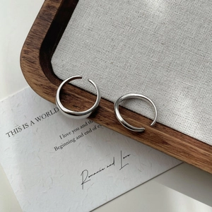 Minimalist irregular 925 silver rings set on a clean aesthetic wooden display