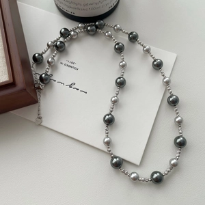 Detail of grey pearl necklace with S925 sterling silver tag and intricate metal spacers