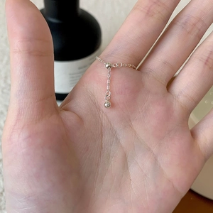 Detail of S925 sterling silver chain ring with a small round bead charm on a hand