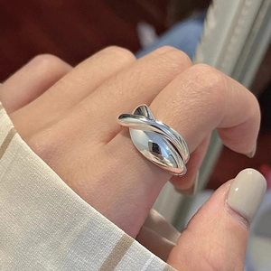Close-up of a crossover silver irregular ring showing polished metal texture on a hand