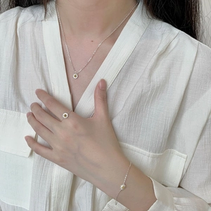 Detailed view of daisy jewelry set including necklace, ring and bracelet on model